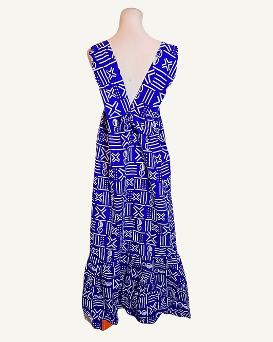 Robe longue wax bleu roi à motifs bogolan blancs, dos nu ouvert en V profond, bretelles larges, volant en bas d'ourlet, longueur cheville · exemplaire unique Giwax Boutique.