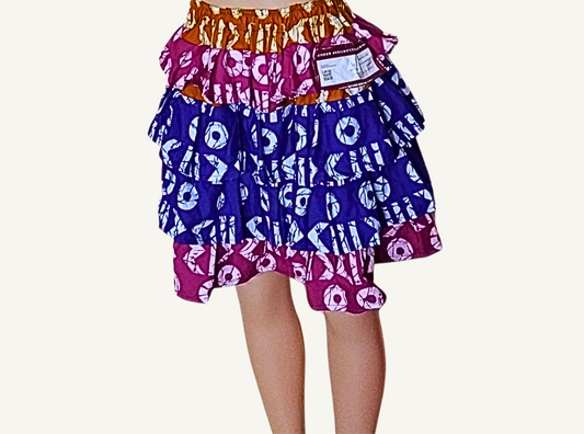 Jupe à volants étagés patchwork wax africain · caramel · fuchsia · bleu roi · motifs cercles et symboles · taille élastiquée · pièce unique — M/L