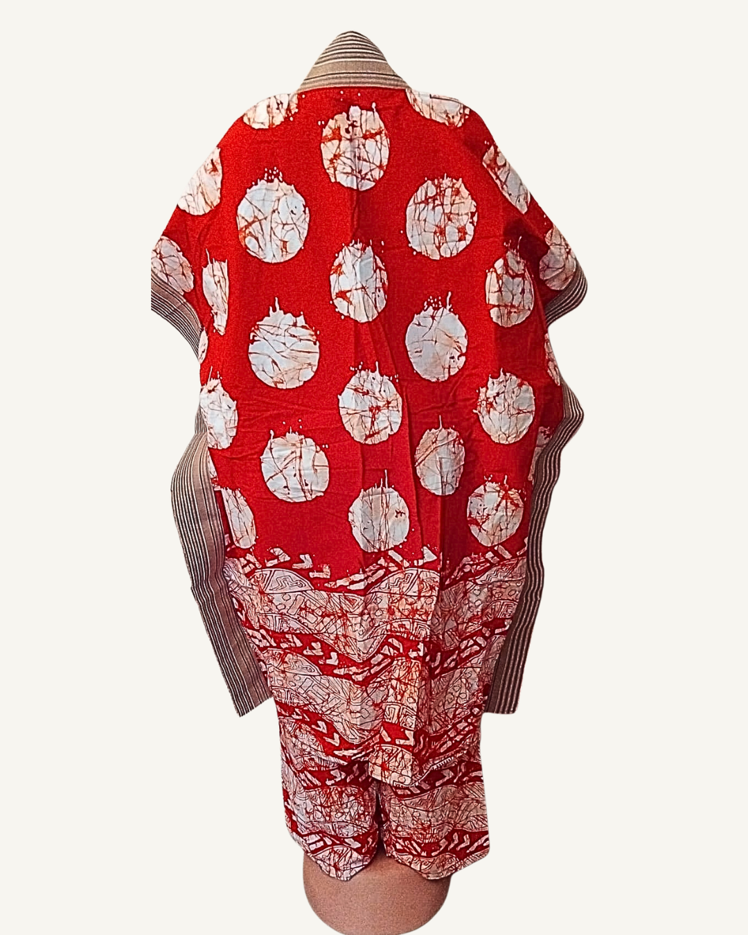 Vue dos — veste kimono batik africain rouge, grands cercles blancs couvrant tout le dos, bordure inférieure de symboles entrelacés rouge et blanc, large finition rayée beige sur les côtés et les manches.