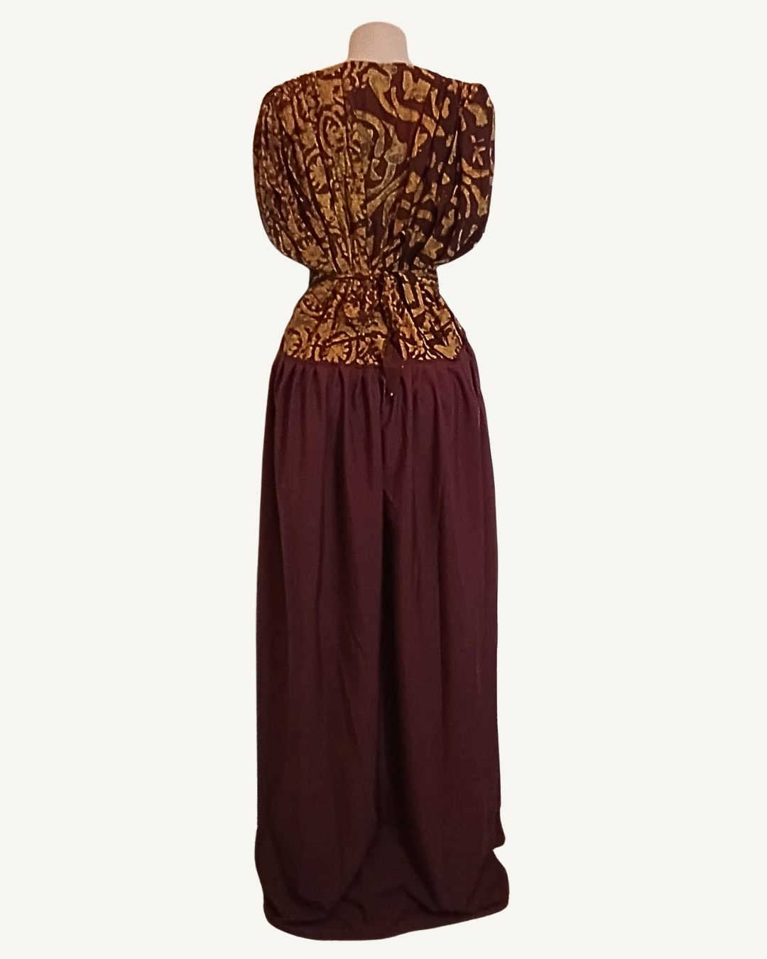 Dos d'une robe longue batik doré arabesques, ceinture intégrée nouée dans le dos, jupe unie bordeaux fluide longueur sol · exemplaire unique Giwax Boutique.