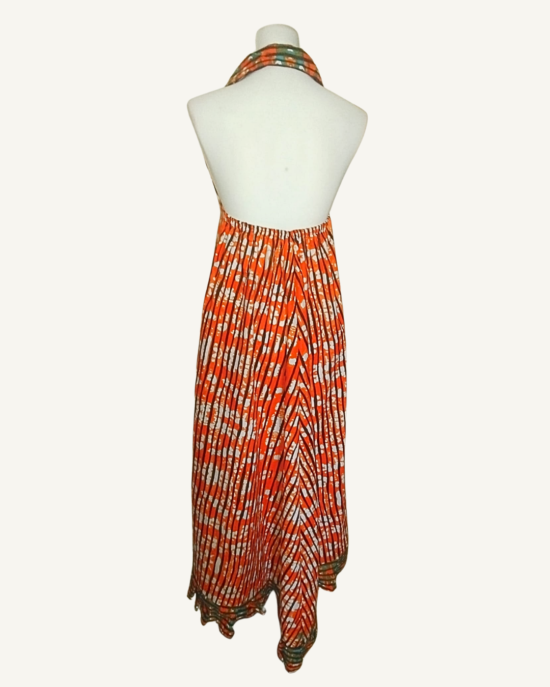 Robe longue batik orange à rayures diagonales africaines, dos entièrement nu, col halter avec revers, buste élastiqué, ourlet asymétrique en pointes · exemplaire unique Giwax Boutique.