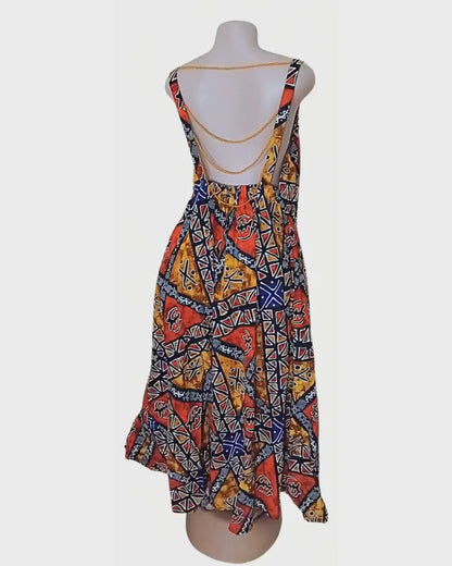 Robe batik multicolore · motifs africains graphiques · dos nu chaîne dorée · exemplaire unique