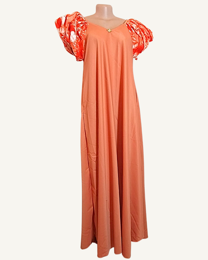 Robe longue corail rosé portée sans corset, manches bouffantes wax orange, coupe très ample et fluide longueur cheville · exemplaire unique Giwax Boutique.