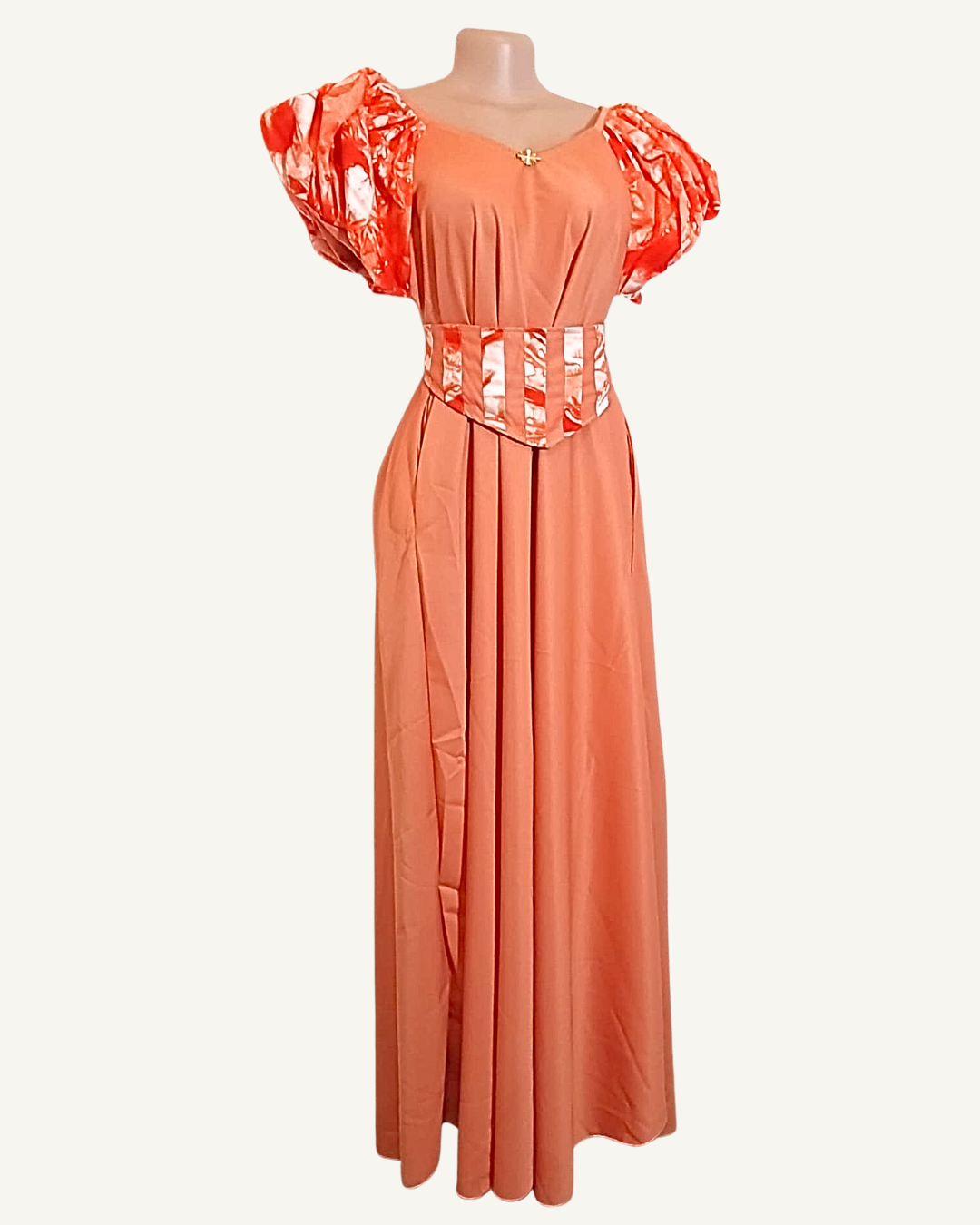 Robe longue corail rosé, manches bouffantes volumineuses en wax orange satiné, corset amovible assorti à la taille, bouton doré au décolleté V · exemplaire unique Giwax Boutique.
