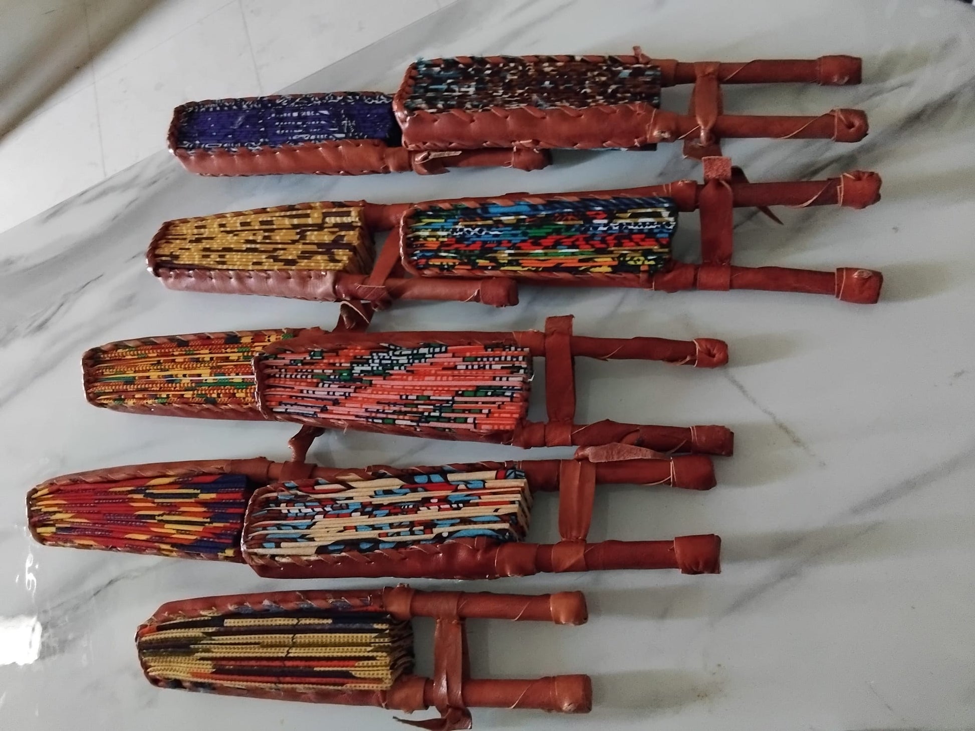 Collection d'éventails artisanaux en wax motifs africains variés · faits main Côte d'Ivoire · Giwax Boutique.