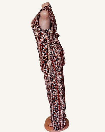 Vue de profil · ensemble wax africain terracotta et sable · blazer sans manches col retourné cintré · pantalon palazzo large · bandes verticales de motifs géométriques losanges croix triangles · longueur cheville.