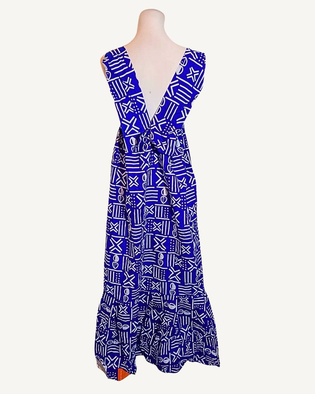 Robe longue wax bleu roi à motifs bogolan blancs, dos nu ouvert en V profond, bretelles larges, volant en bas d'ourlet, longueur cheville · exemplaire unique Giwax Boutique.
