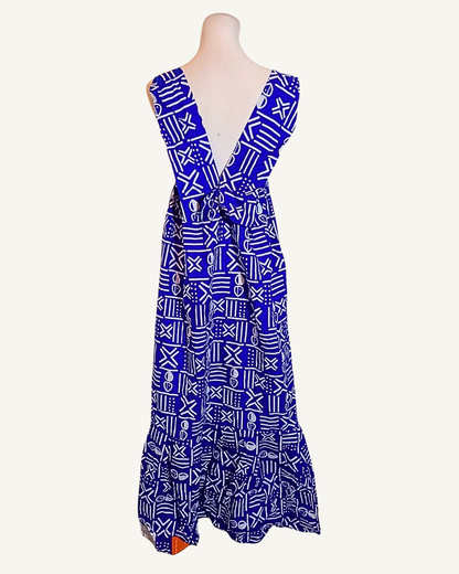 Robe longue wax bleu roi à motifs bogolan blancs, dos nu ouvert en V profond, bretelles larges, volant en bas d'ourlet, longueur cheville · exemplaire unique Giwax Boutique.