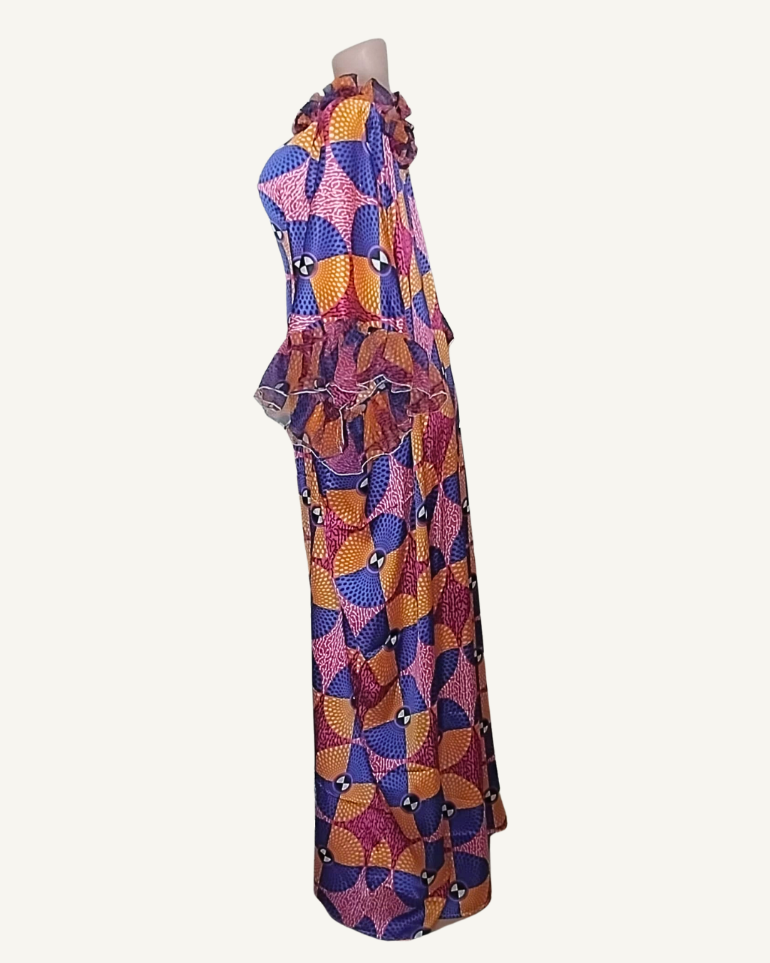 Vue de profil · volume du double volant des manches bien visible · col froncé cordon · tombé caftan très ample longueur cheville · motif éventails géométrique violet ocre rose.
