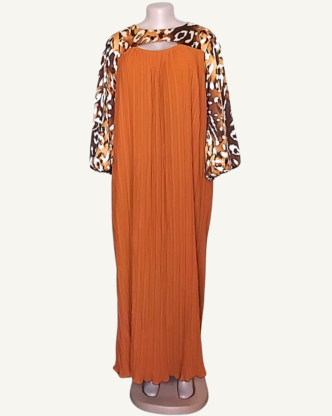 Robe longue plissée terracotta brûlé · empiècement haut et manches trois-quarts bouffantes en imprimé léopard ocre doré brun et blanc · col rond · coupe très ample · longueur cheville · micro-plis verticaux visibles sur tout le corps.