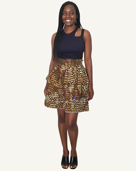Jupe courte à trois volants étagés froncés en imprimé africain kaki doré or brûlé · textures organiques abstraites · taille élastiquée · ourlet bordé blanc · longueur genou · portée avec crop top noir (couleur non choisissable à la commande).