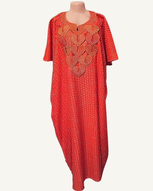 Boubou long rouge corail à motifs nids d'abeille relief avec sequins et strass ton sur ton, grand plastron brodé de cinq cœurs imbriqués en fils or cuivré et champagne avec volutes, col arrondi liseré doré avec zip central, manches courtes droites, coupe caftan ample longueur chevilles.