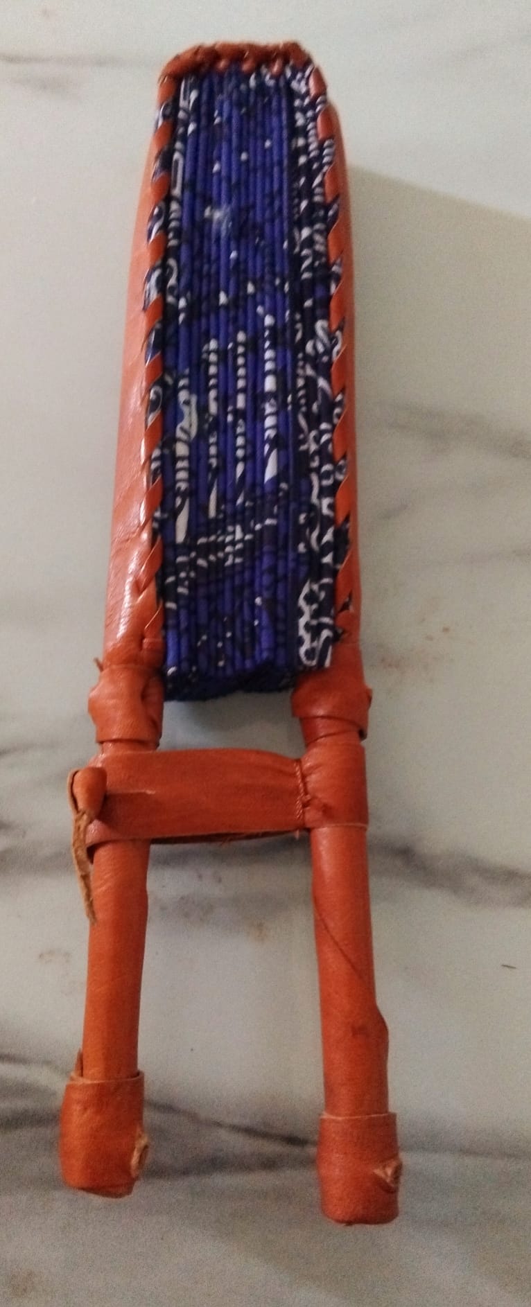 Éventails artisanaux pliés montrant la monture similicuir terracotta et les tiges en bois · Giwax Boutique.