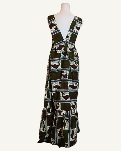Robe longue wax vert kaki et bordeaux, motifs en damier avec silhouettes d'animaux africains, dos nu ouvert en V profond, bretelles larges, volant plissé longueur cheville · exemplaire unique Giwax Boutique.
