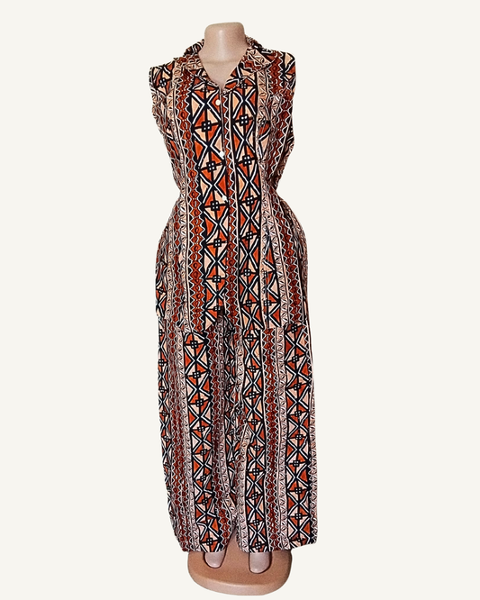 Vue face · blazer wax terracotta sans manches · col retourné · boutonnage devant · taille cintrée · pans asymétriques · motifs géométriques en bandes verticales · pantalon palazzo même tissu.