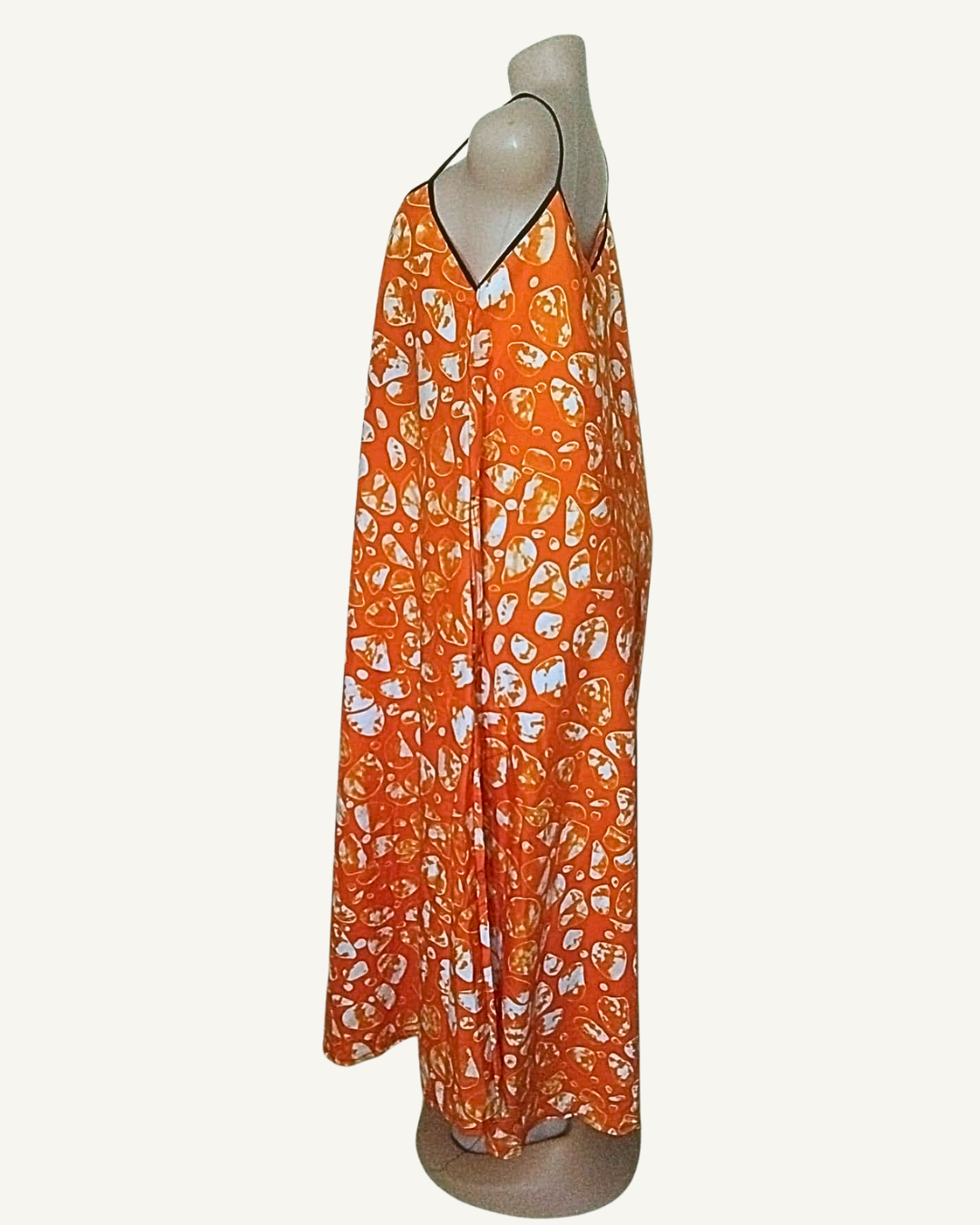 Robe longue batik orange vif, motifs organiques blancs et dorés, bretelles fines liseré noir, coupe trapèze très ample, ourlet asymétrique longueur cheville · exemplaire unique Giwax Boutique.