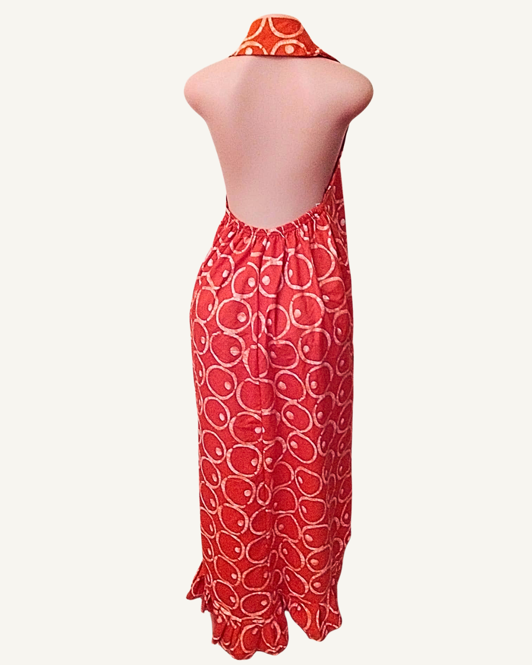Vue dos — robe batik rouge dos entièrement nu, attache halter nouée à la nuque, froncé élastiqué bas du dos, coupe droite maxi jusqu'à la cheville avec volant en ourlet.