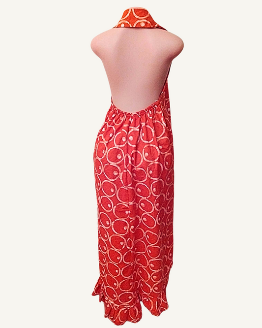 Vue dos — robe batik rouge dos entièrement nu, attache halter nouée à la nuque, froncé élastiqué bas du dos, coupe droite maxi jusqu'à la cheville avec volant en ourlet.