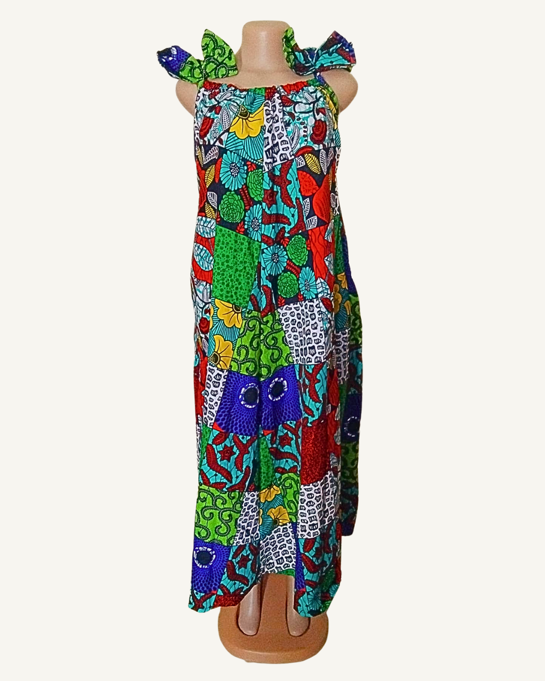 Robe wax africaine imprimée façon patchwork multicolore, turquoise · rouge · vert · jaune · bleu marine, bretelles larges à nœuds volantés, encolure arrondie élastiquée, coupe maxi · exemplaire unique Giwax Boutique.