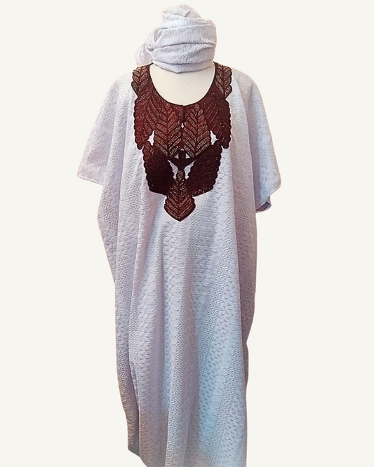 Ensemble boubou long en brocart africain blanc à motifs jacquard en relief, plastron brodé marron profond en forme d'oiseau symétrique aux feuilles nervurées, col arrondi, manches courtes larges, coupe caftan ample longueur cheville, foulard assorti drapé en tête.