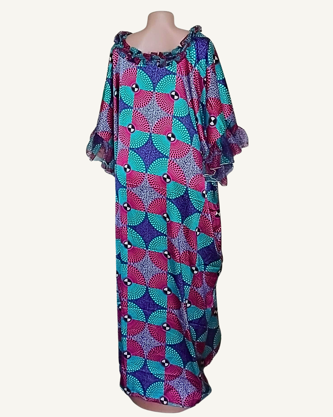 Vue dos légèrement de côté · volume des manches évasées double volant bien visible · col froncé · tombé caftan très ample longueur cheville · motif éventails géométrique turquoise rose violet.