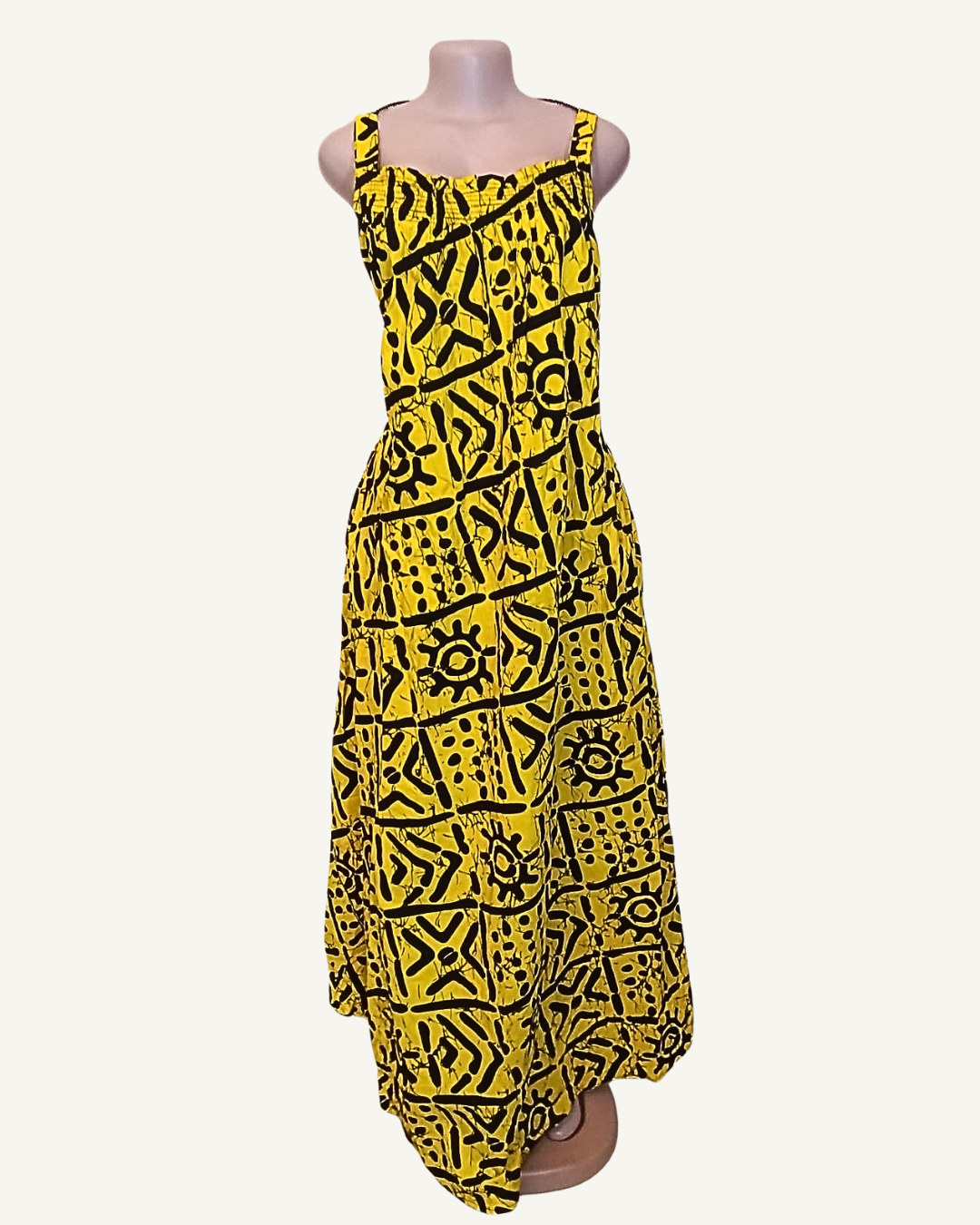 Robe batik africain jaune soleil intense · symboles noirs graphiques tribaux · bustier smocké élastiqué · bretelles larges · jupe évasée ample · ourlet asymétrique · longueur midi à cheville.