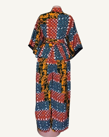 Vue dos · ensemble wax africain patchwork bleu rouge et ocre · top peplum évasé ceinturé · manches courtes · pantalon · longueur cheville · blocs de motifs distincts pois losanges et batik.