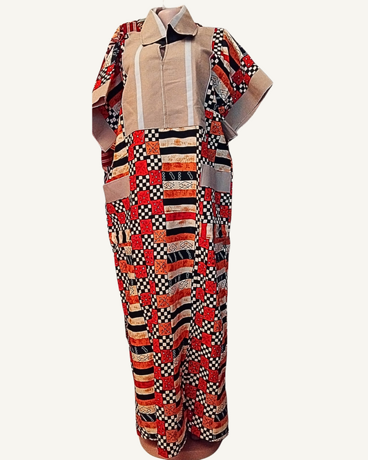 Vue de profil — robe longue batik africain patchwork rouge noir et orange, empiècement beige lin avec col chemise et zip central, manche courte batik à revers beige, poche plaquée beige visible sur le côté, coupe droite ample longueur cheville.