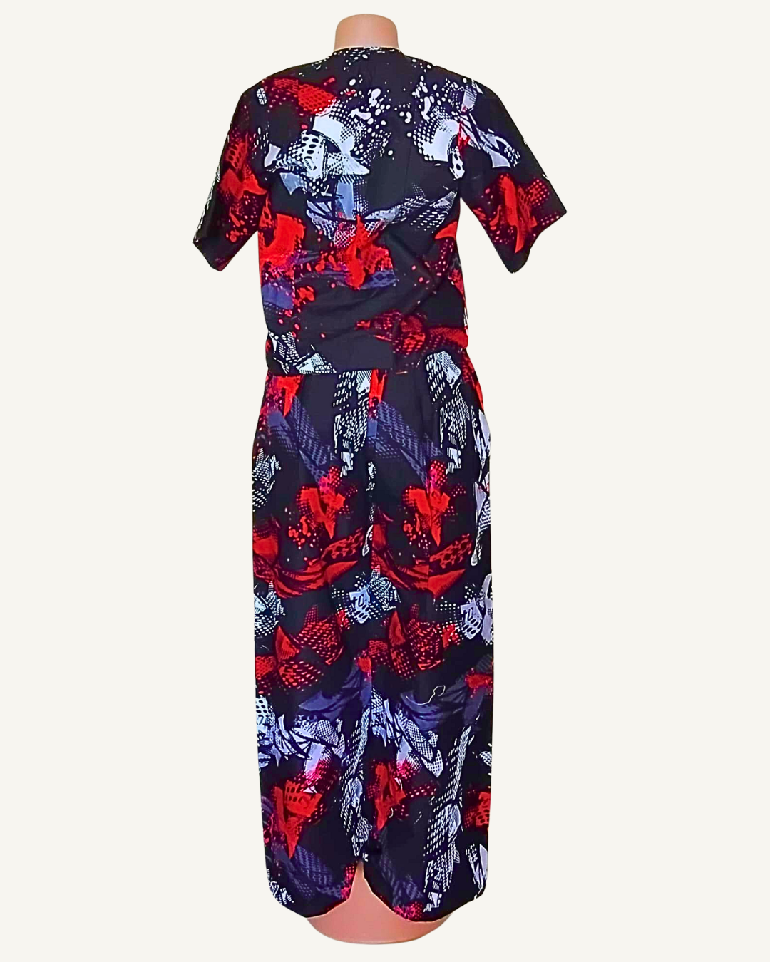 Vue dos · top imprimé abstrait noir rouge sans détail particulier · pantalon même imprimé · fente basse dos · bandes latérales rayées visibles · longueur cheville.