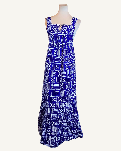Robe longue wax bleu roi, motifs géométriques blancs style bogolan, encolure carrée, bretelles larges, boutons dorés décoratifs sur le devant, coupe évasée longueur cheville · exemplaire unique Giwax Boutique.