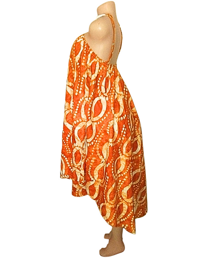Robe batik orange brûlé à motifs en arceaux et points crème, coupe trapèze très ample, ourlet asymétrique court devant et long derrière · exemplaire unique Giwax Boutique.