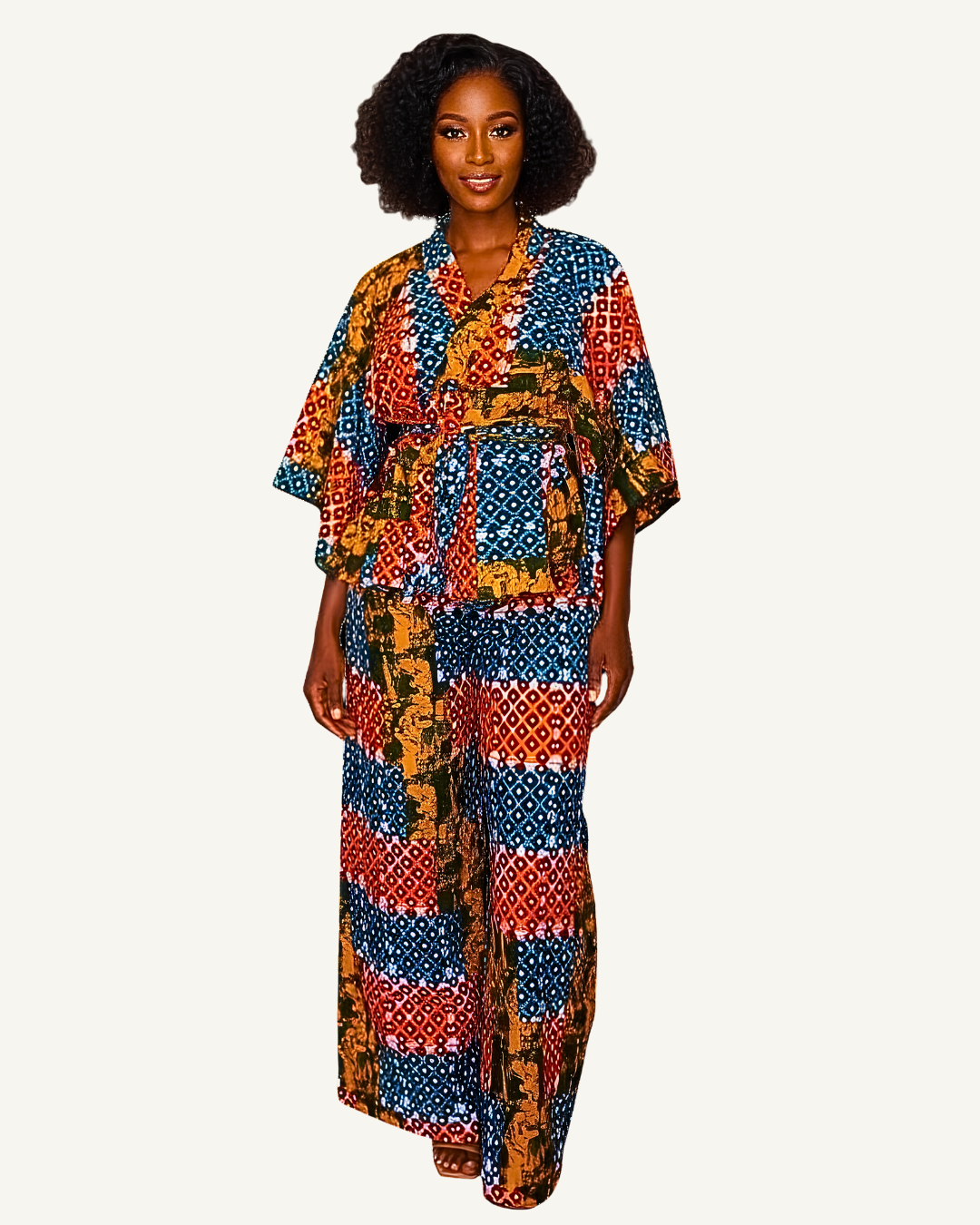 Ensemble wax patchwork porté · top col V croisé peplum · ceinture nouée · pantalon coordonné · bleu nuit · rouge brique · ocre doré · pose décontractée et élégante.