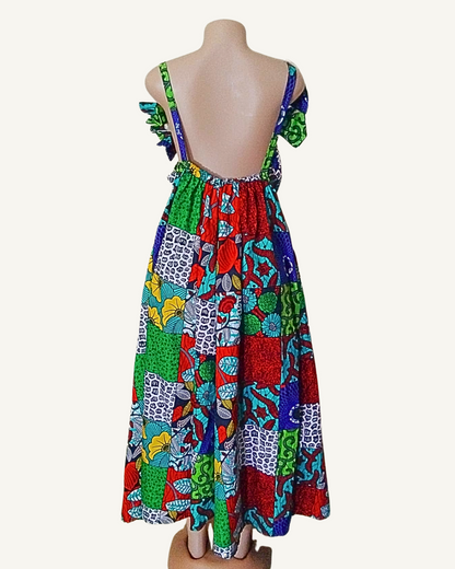 Dos entièrement nu d'une robe wax patchwork multicolore, bretelles larges à volants, buste élastiqué, coupe évasée et généreuse longueur maxi.