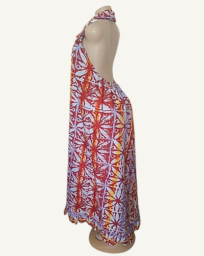 Robe longue batik bordeaux et bleu, profil montrant la coupe trapèze ample, le dos nu et le tombé fluide jusqu'à la cheville.