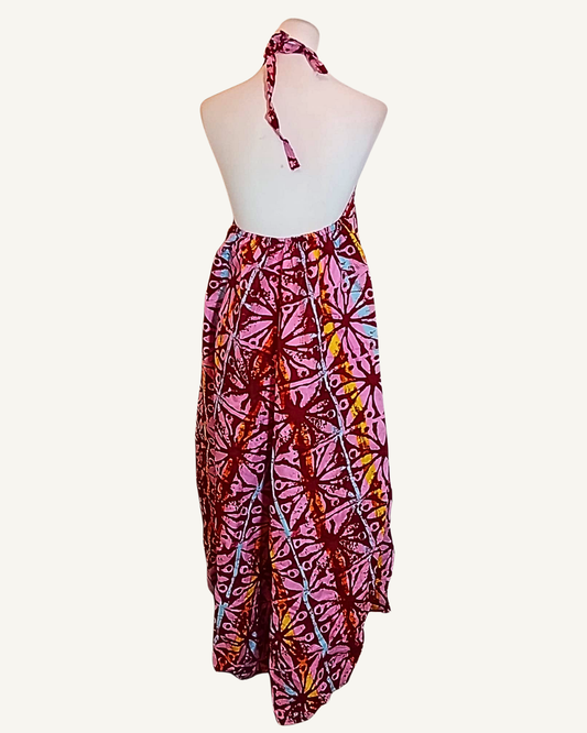 Dos entièrement nu d'une robe longue batik rose, col halter noué dans le dos, buste élastiqué, coupe évasée ourlet asymétrique tombant en pointe · exemplaire unique Giwax Boutique.